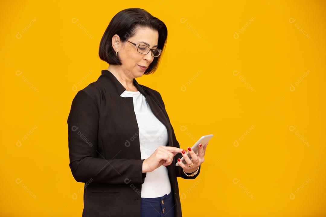 Foto de uma empresária madura atraente trabalhando com seu telefone celular