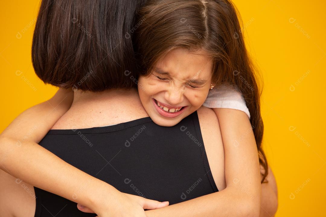 Retrato de uma garotinha chorando que está sendo segurada por sua mãe