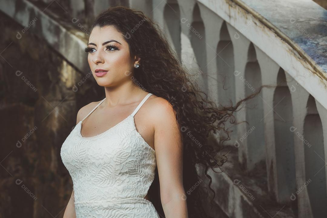 Mulher morena brasileira do cabelo cacheado da blusa branca