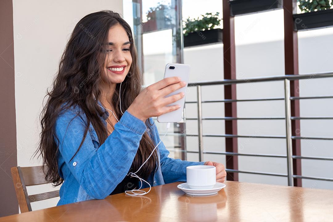 Mulher jovem elegante e bem sucedida mexendo no smartphone