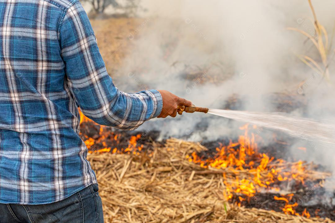 Queimaduras grama seca desastre natural. Agricultor tentando apagar fogo grande campo queimado