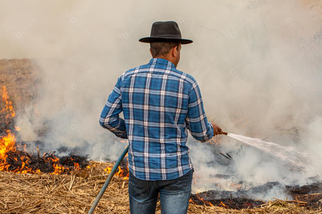 Queimaduras grama seca desastre natural. Agricultor tentando apagar fogo grande campo queimado