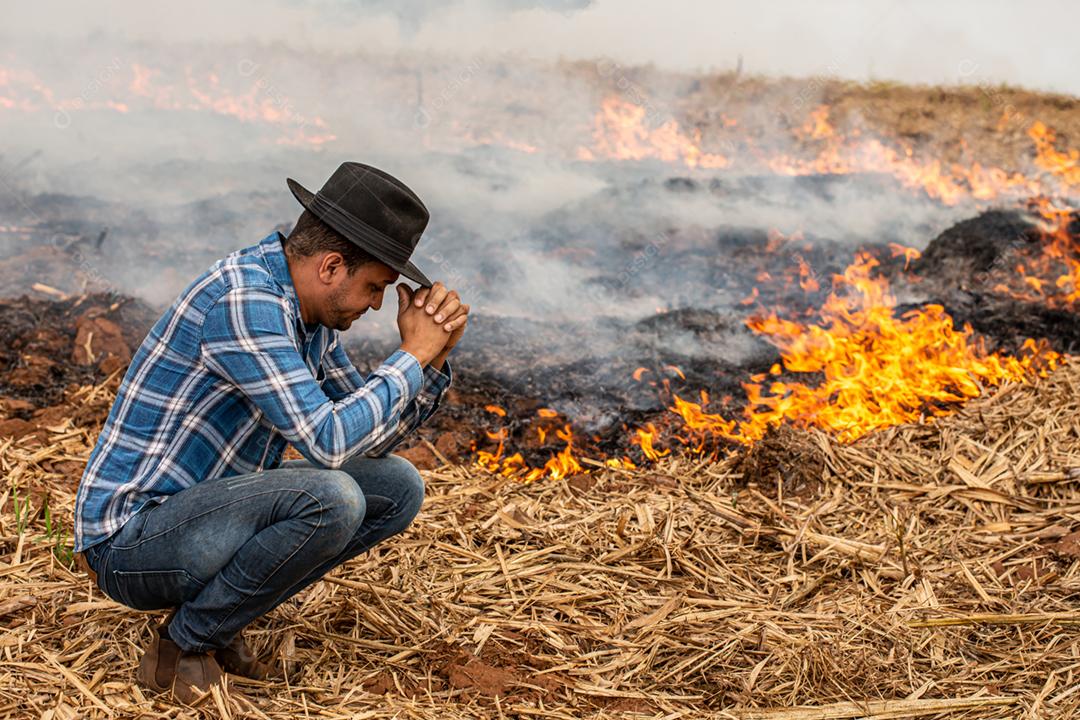 Agricultor desesperado para que fogo atinja sua fazenda. Queimado dias secos destruindo fazenda.