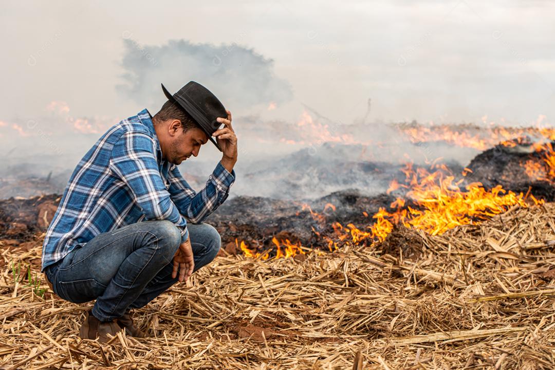 Agricultor desesperado para que fogo atinja sua fazenda. Queimado dias secos destruindo fazenda.
