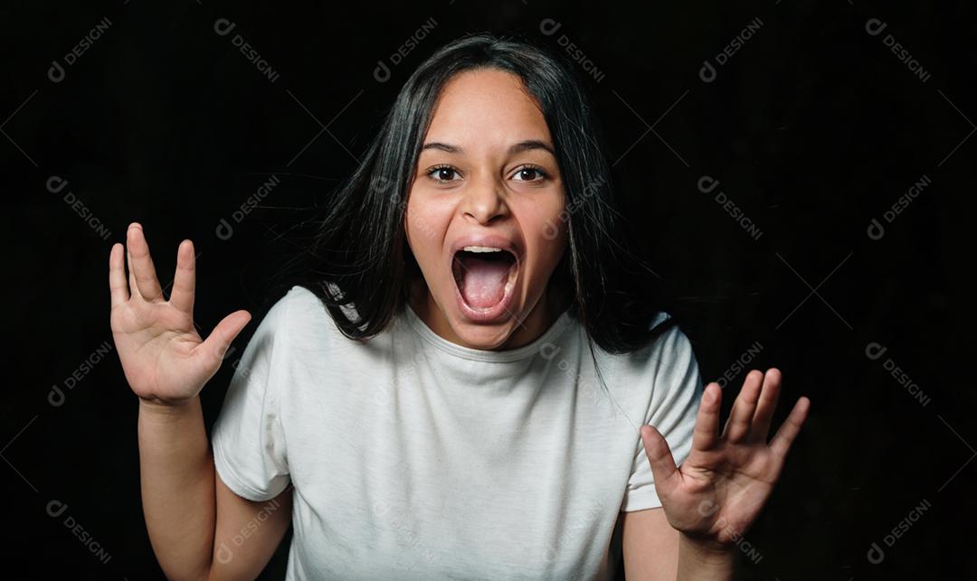 Mulher adolescente gritando selvagem e louco com energia total, olhando para a câmera