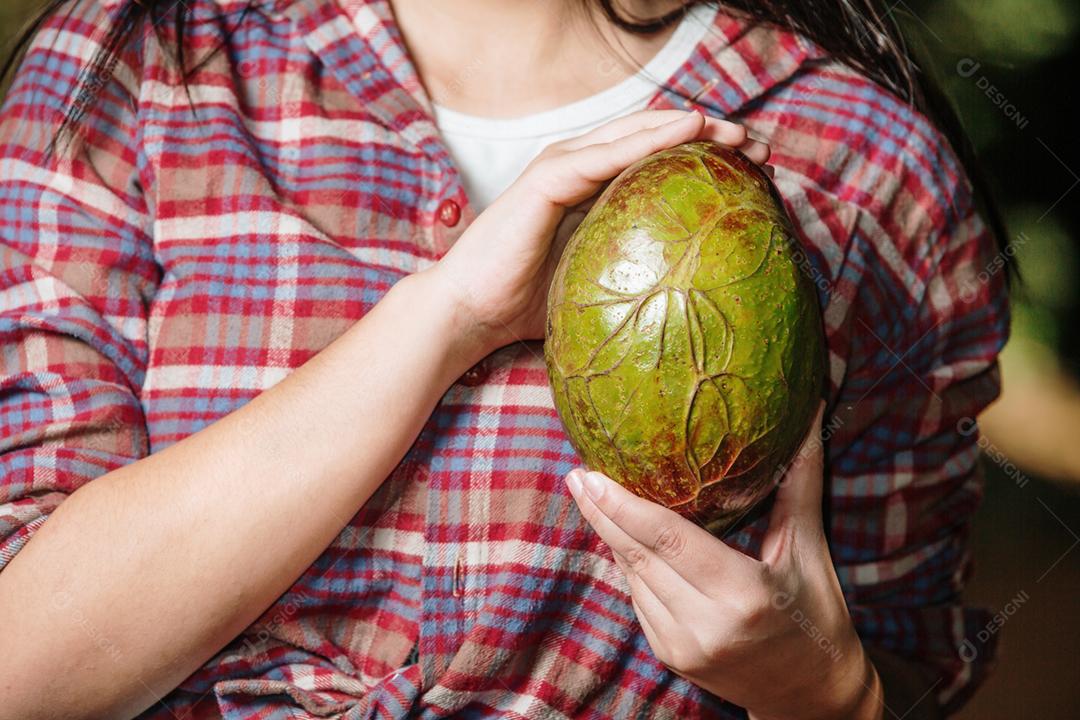 Jovem segurando abacate forma semelhante coração. O abacate é um alimento