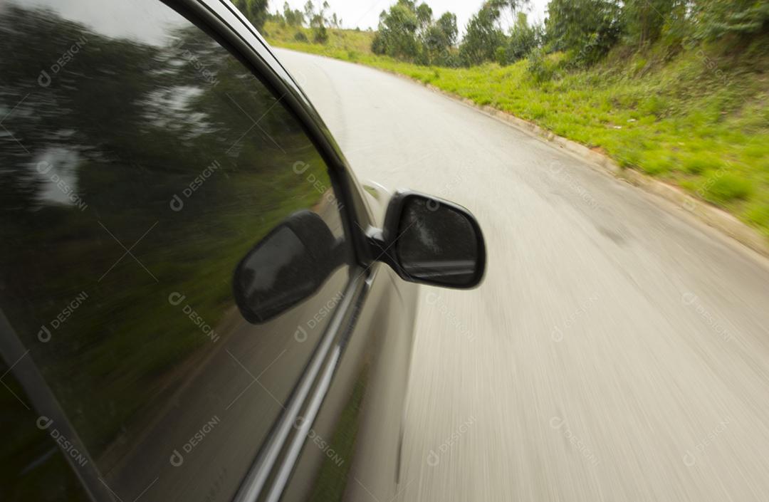 Acelere o carro preto em uma curva na estrada.