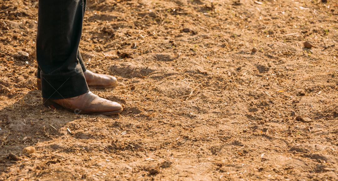 Concentre-se nos pés de um fazendeiro no curral.