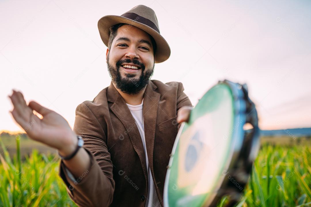 Ao ar livre de um jovem latino-americano tocando pandeiro. músico brasileiro.