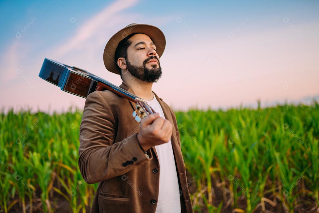 Ao ar livre de um jovem latino-americano e guitarra. músico brasileiro.