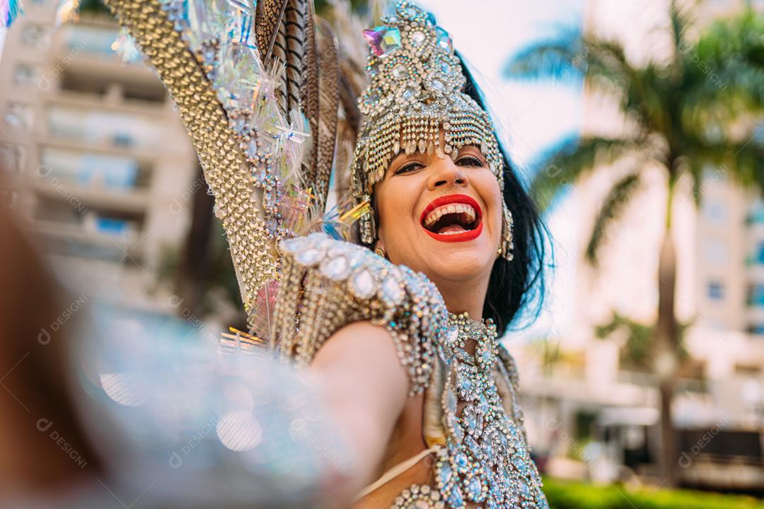 Linda mulher brasileira vestindo fantasia carnaval colorida e sorrindo durante o desfile de rua