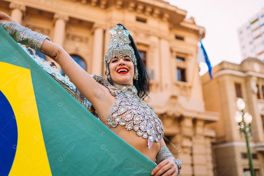 Linda mulher brasileira vestindo fantasia de carnaval colorida e bandeira do Brasil
