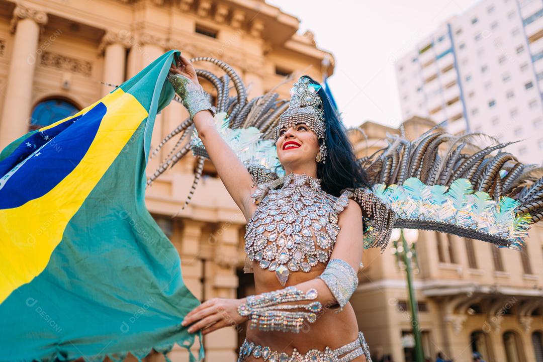 Linda mulher brasileira vestindo fantasia de carnaval colorida e bandeira do Brasil