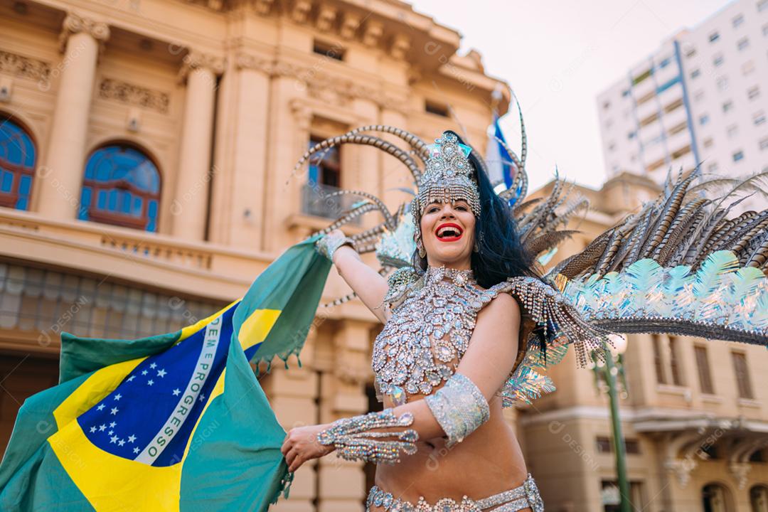 Linda mulher brasileira vestindo fantasia de carnaval colorida e bandeira do Brasil