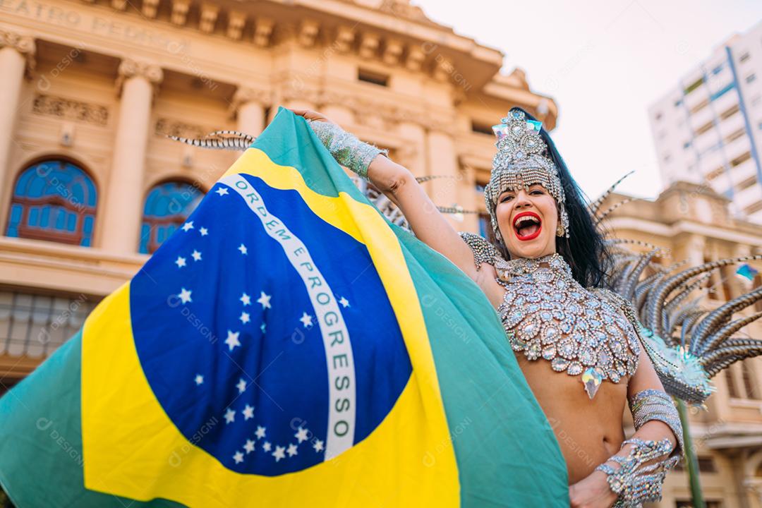 Linda mulher brasileira vestindo fantasia de carnaval colorida e bandeira do Brasil