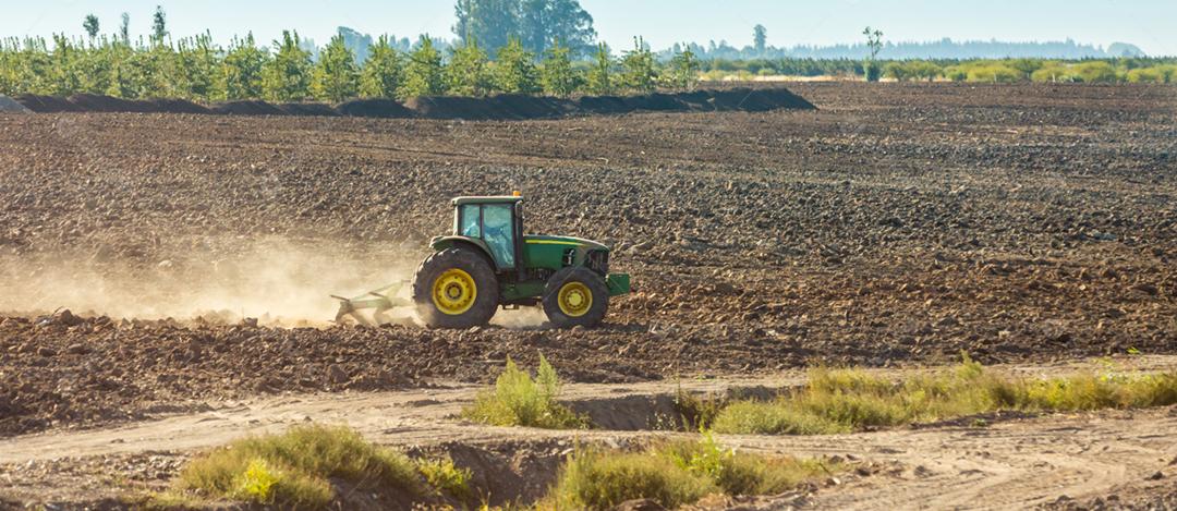Trator arando campo agrícola. Agricultor está usando máquinas agrícolas para processo plantio