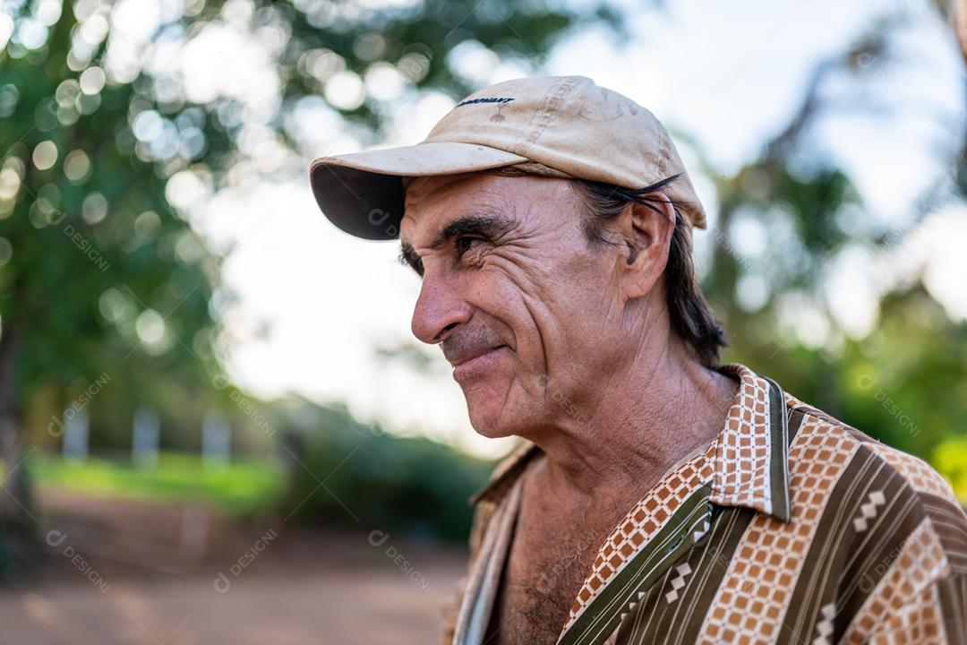 Retrato de sorridente agricultor masculino lindo. Homem na fazenda em dia de verão