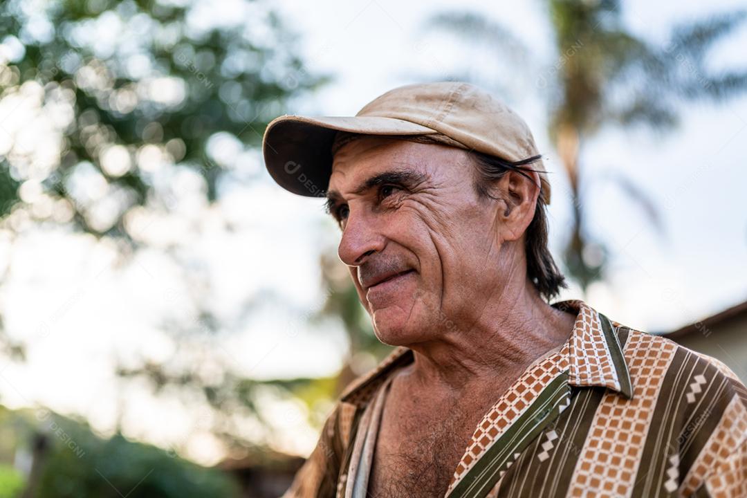 Retrato de sorridente agricultor masculino lindo. Homem na fazenda em dia de verão