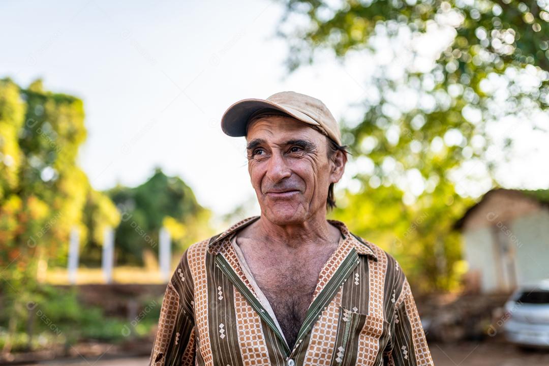 Retrato de sorridente agricultor masculino lindo. Homem na fazenda em dia de verão