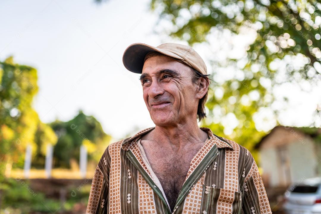 Retrato de sorridente agricultor masculino lindo. Homem na fazenda em dia de verão