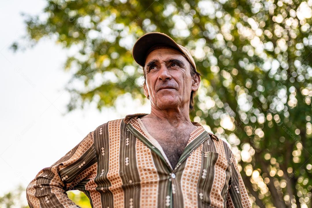 Retrato de sorridente agricultor masculino lindo. Homem na fazenda em dia de verão