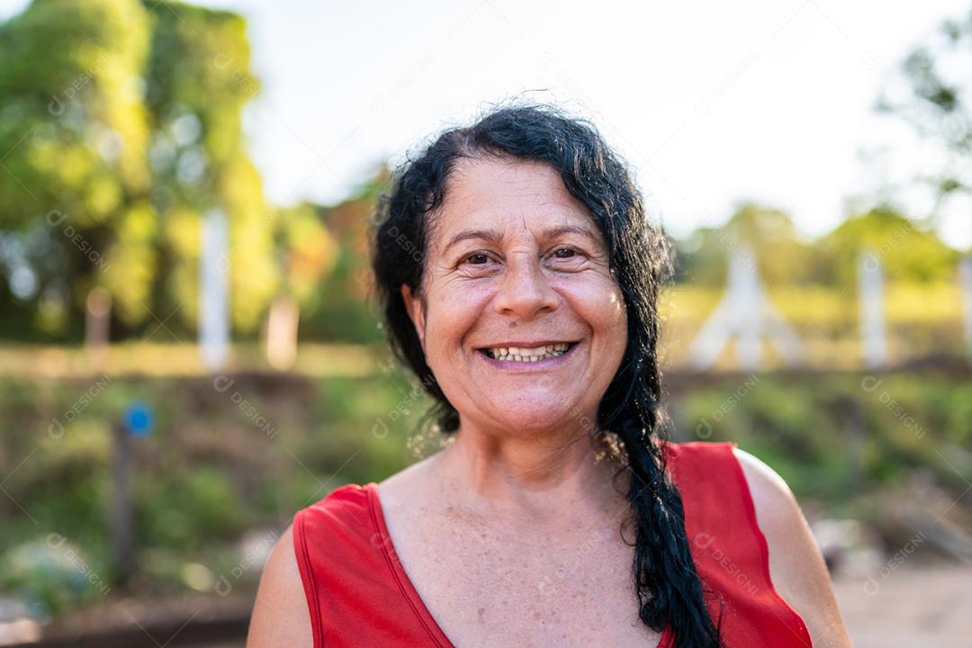 Retrato sorridente bela agricultora. Mulher na fazenda em dia de verão. Atividade de jardinagem