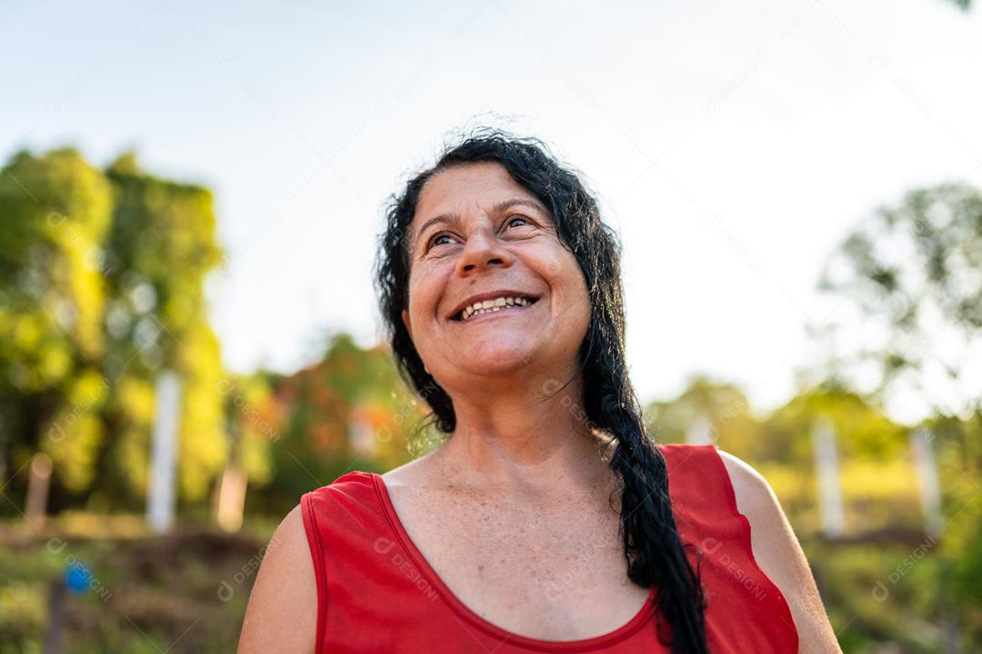 Retrato sorridente bela agricultora. Mulher na fazenda em dia de verão. Atividade de jardinagem