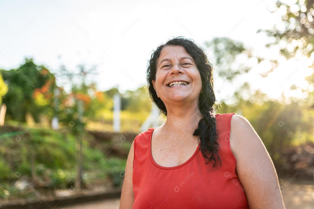 Retrato sorridente bela agricultora. Mulher na fazenda em dia de verão. Atividade de jardinagem