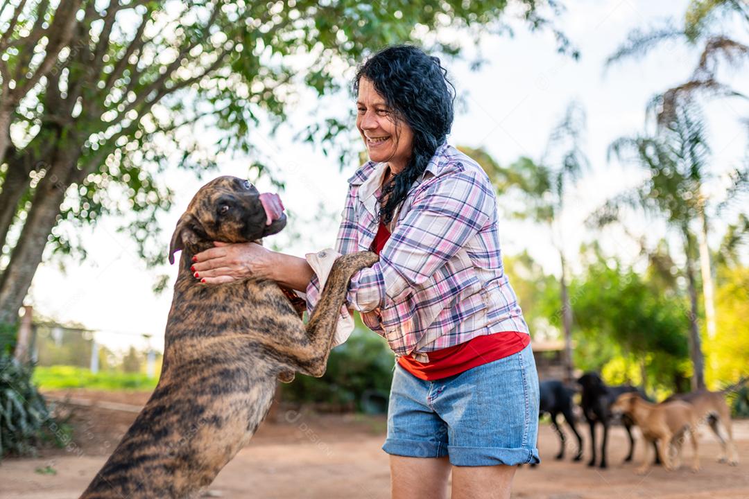 Retrato de sorrindo linda agricultora com um cachorro. Mulher na fazenda em dia de verão00201