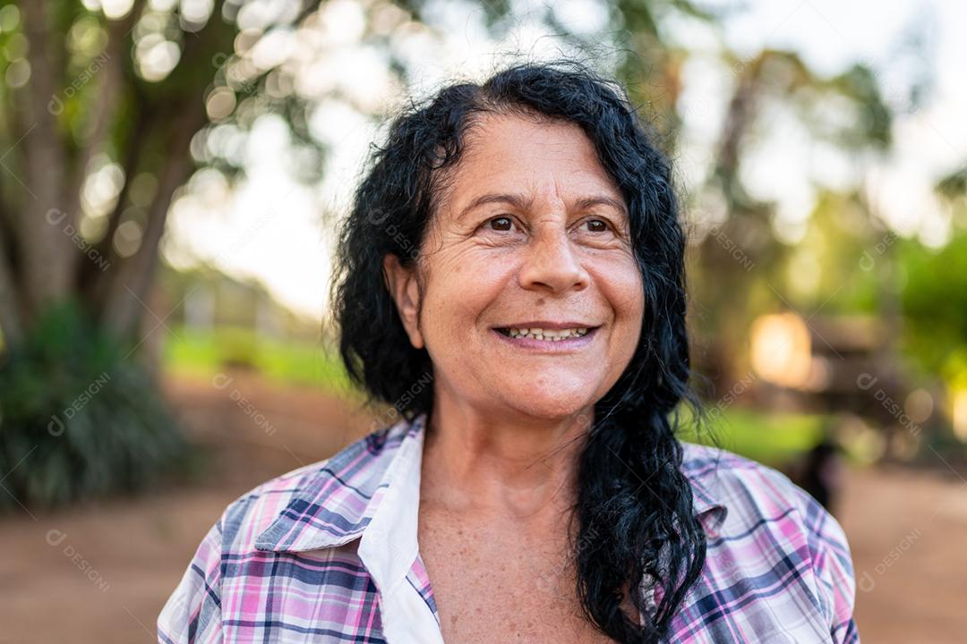 Retrato de agricultor feminino lindo sorridente. Mulher na fazenda em dia de verão.