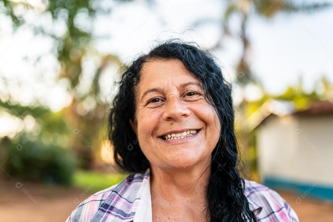 Retrato de agricultor feminino lindo sorridente. Mulher na fazenda em dia de verão.