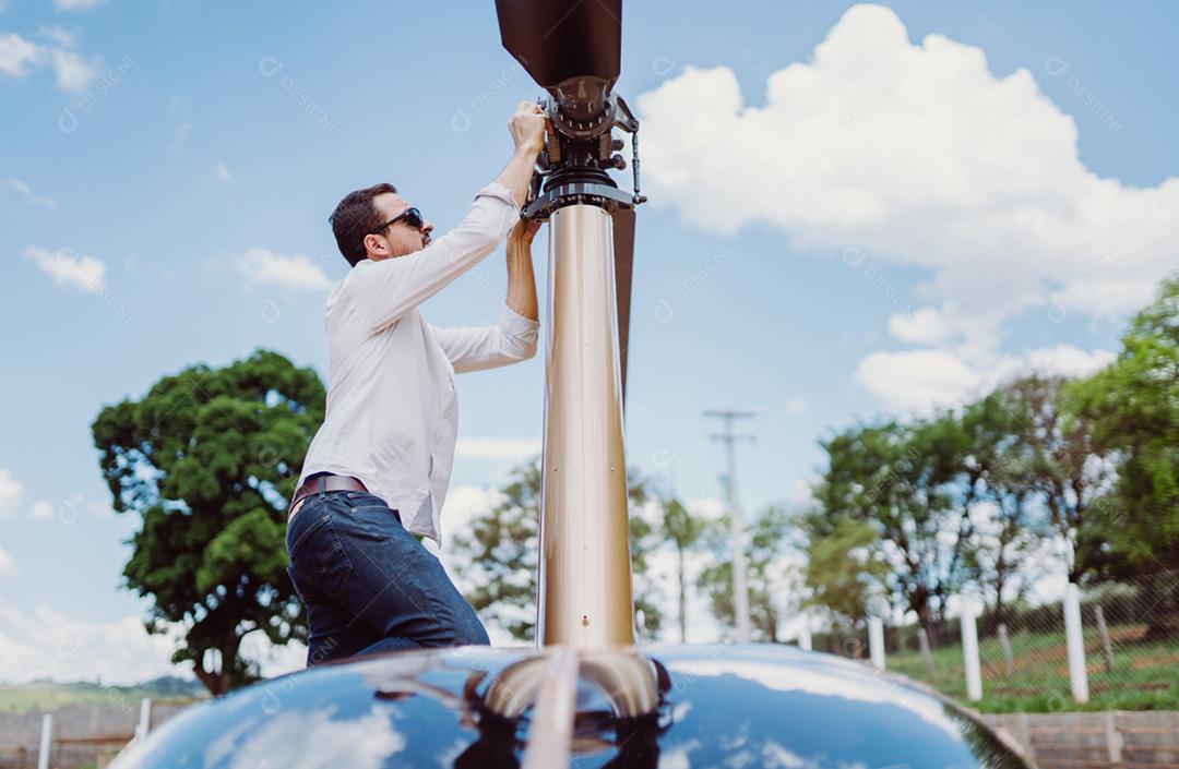 Homem concertano a hélices do helicóptero