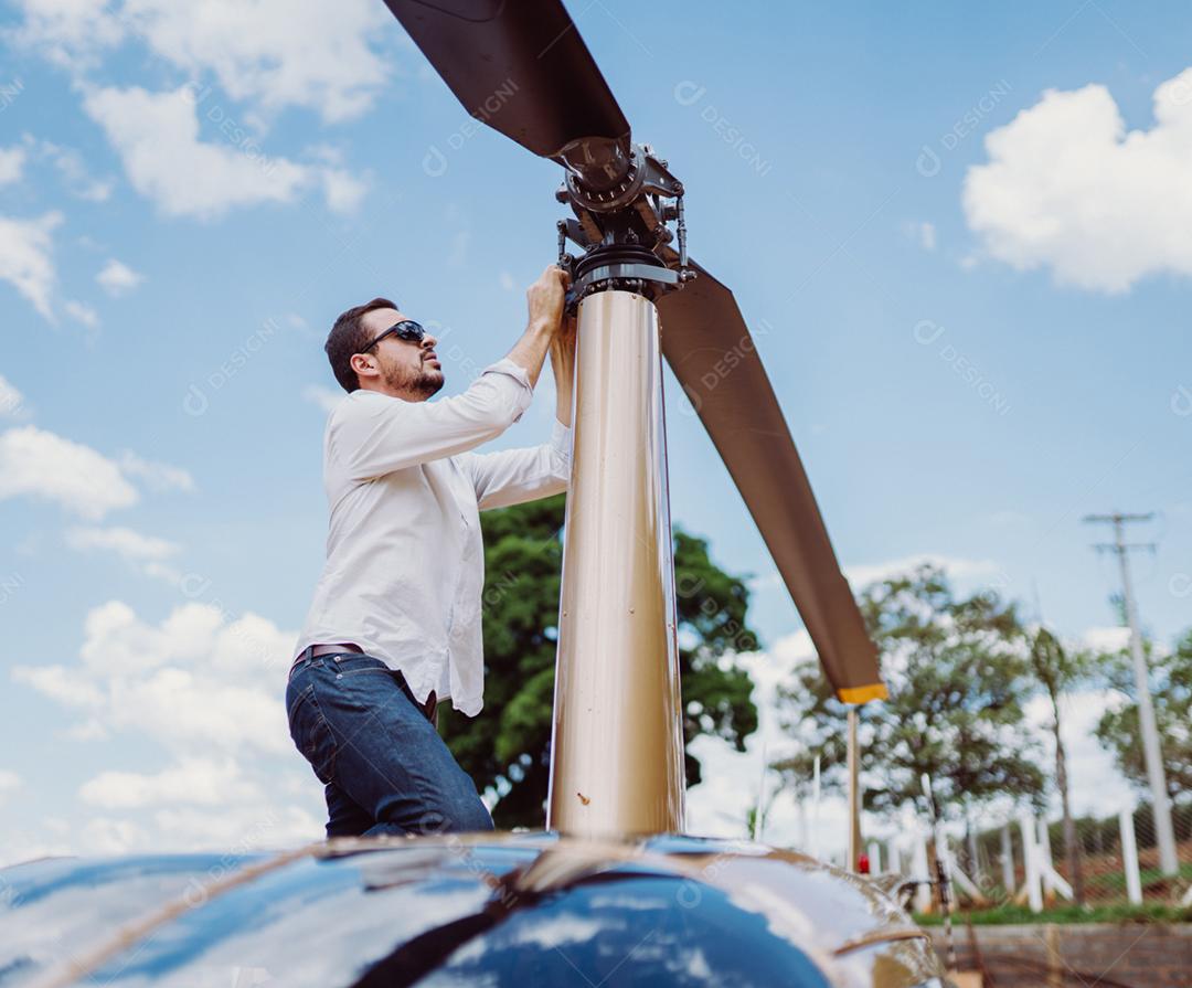 Homem concertano a hélices do helicóptero