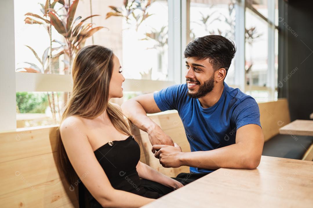 Belo jovem casal latino olhando um ao outro apaixonado.