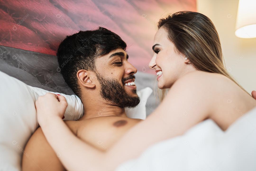 Atraente jovem casal latino na cama.