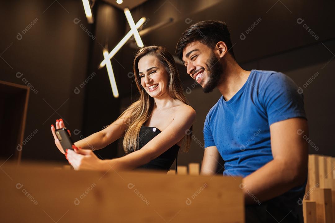 Feliz casal latino fazendo selfie no smartphone.