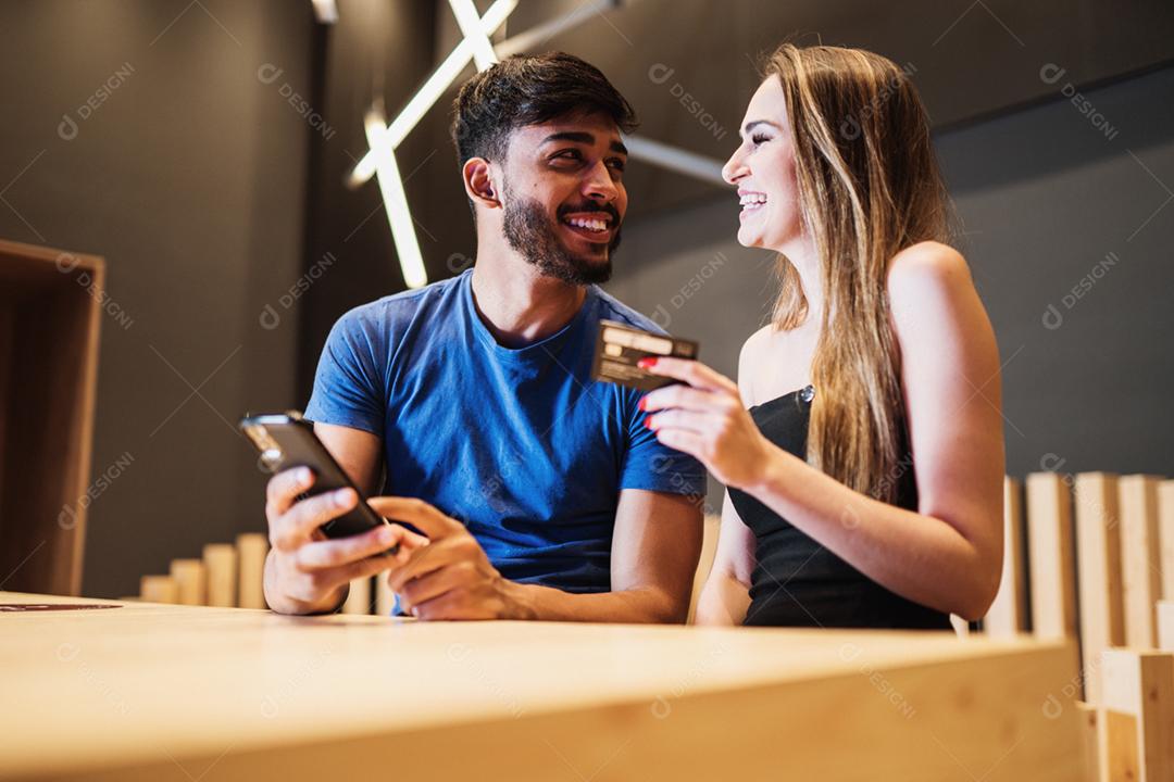 Banco online jovem casal usando smartphone fazendo compras online com cartão de crédito