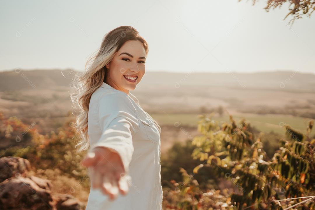 Latin woman extending her hand to the camera, inviting for a trip. Come with me.