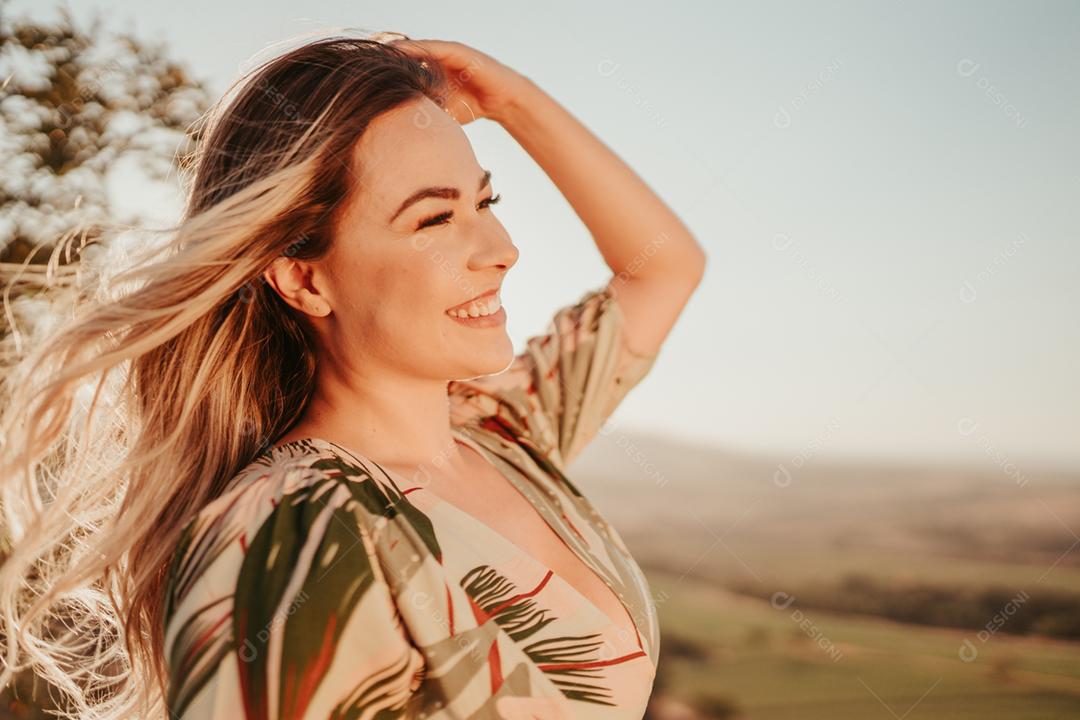 Retrato ao ar livre da bela jovem loira Latina. O cabelo desenvolve-se em um vento.