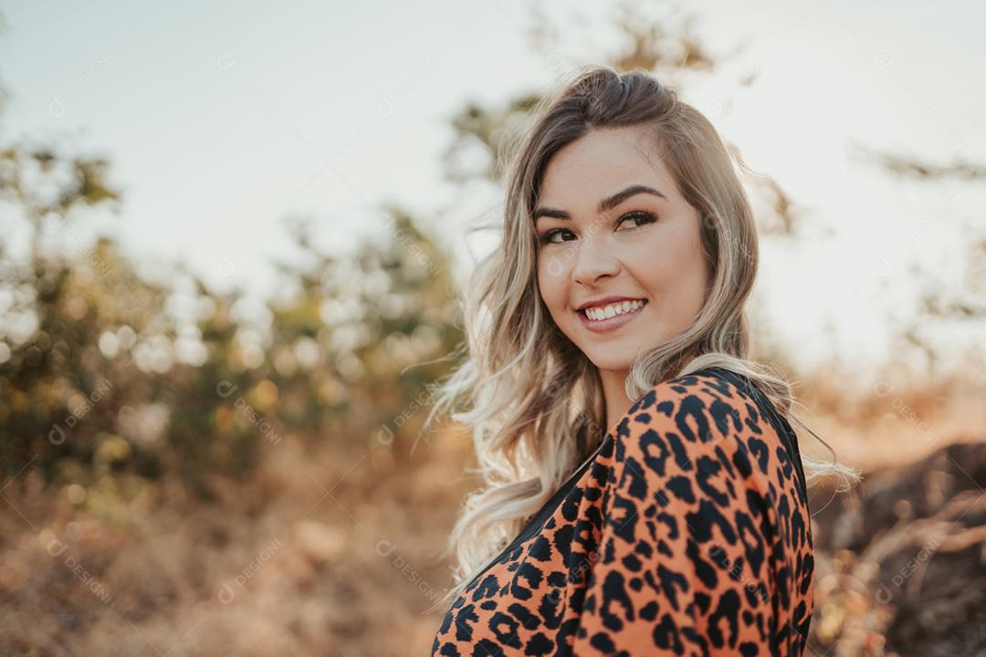 Retrato ao ar livre da bela jovem loira Latina. O cabelo desenvolve-se em um vento.