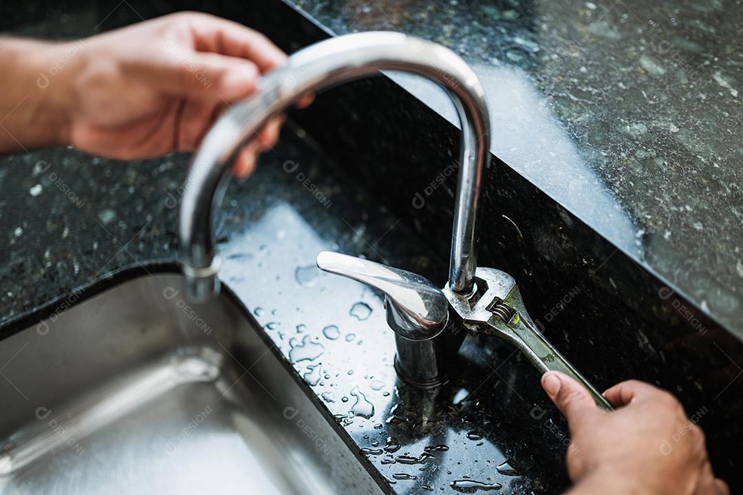 Feche acima das mãos de reparador envelhecido consertando cozinha quebrada nos bater