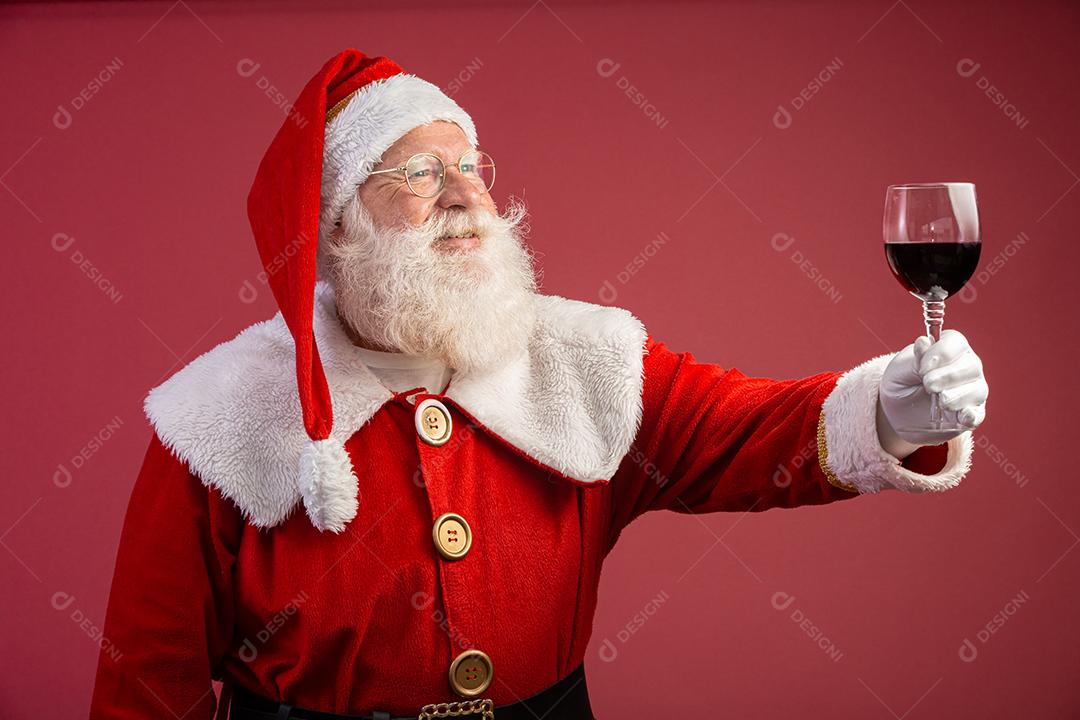 Papai Noel segurando uma taça de vinho na mão. Papai Noel