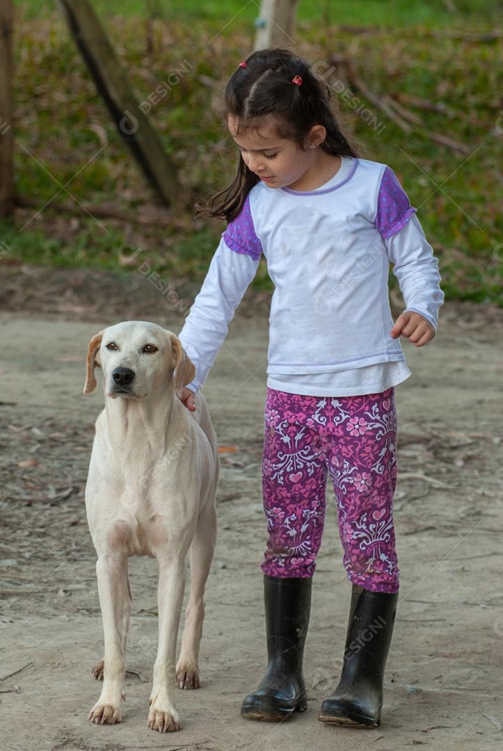 Lindo retrato de uma criança fazendo carinho em um cachorro