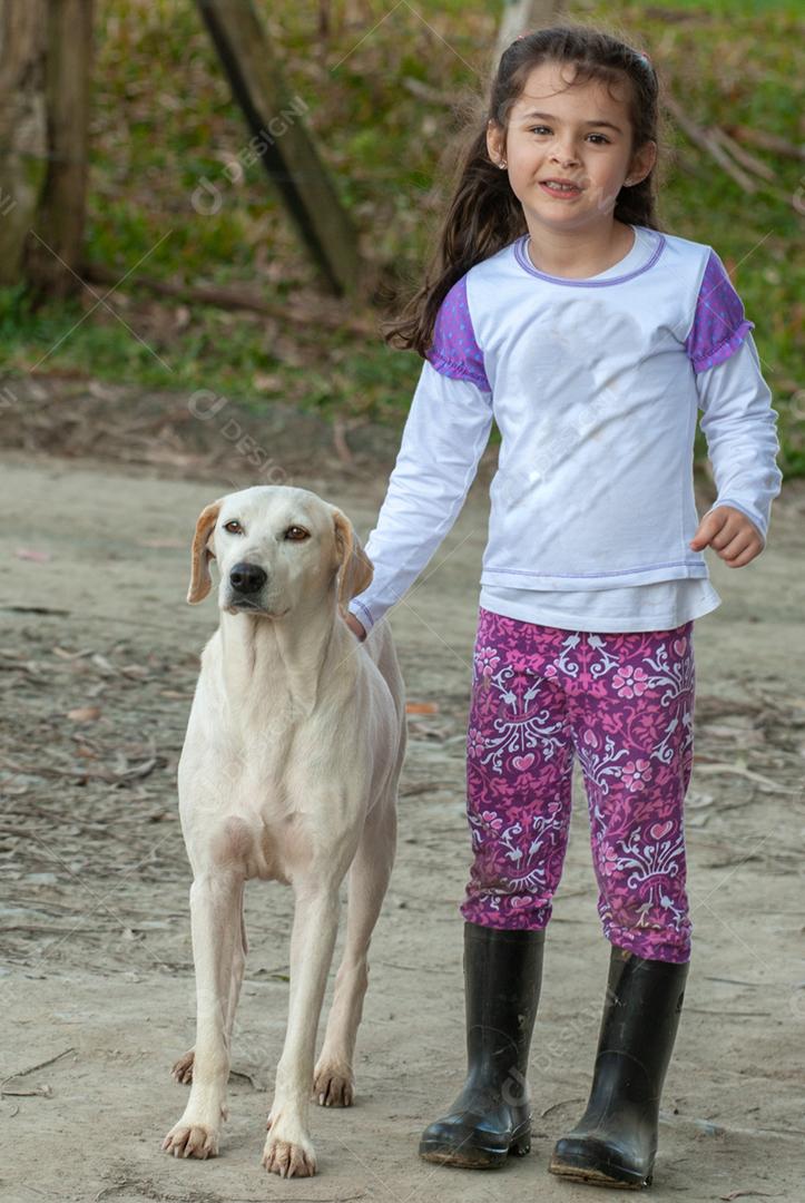 Lindo retrato de uma criança fazendo carinho em um cachorro