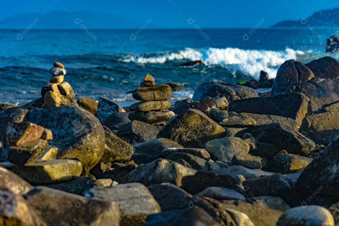 Paisagem por do sol praia pedreiras pedras rochas lago céu nublado