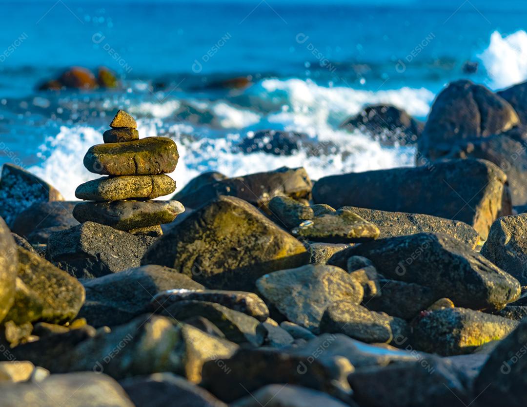 Paisagem por do sol praia pedreiras pedras rochas lago céu nublado