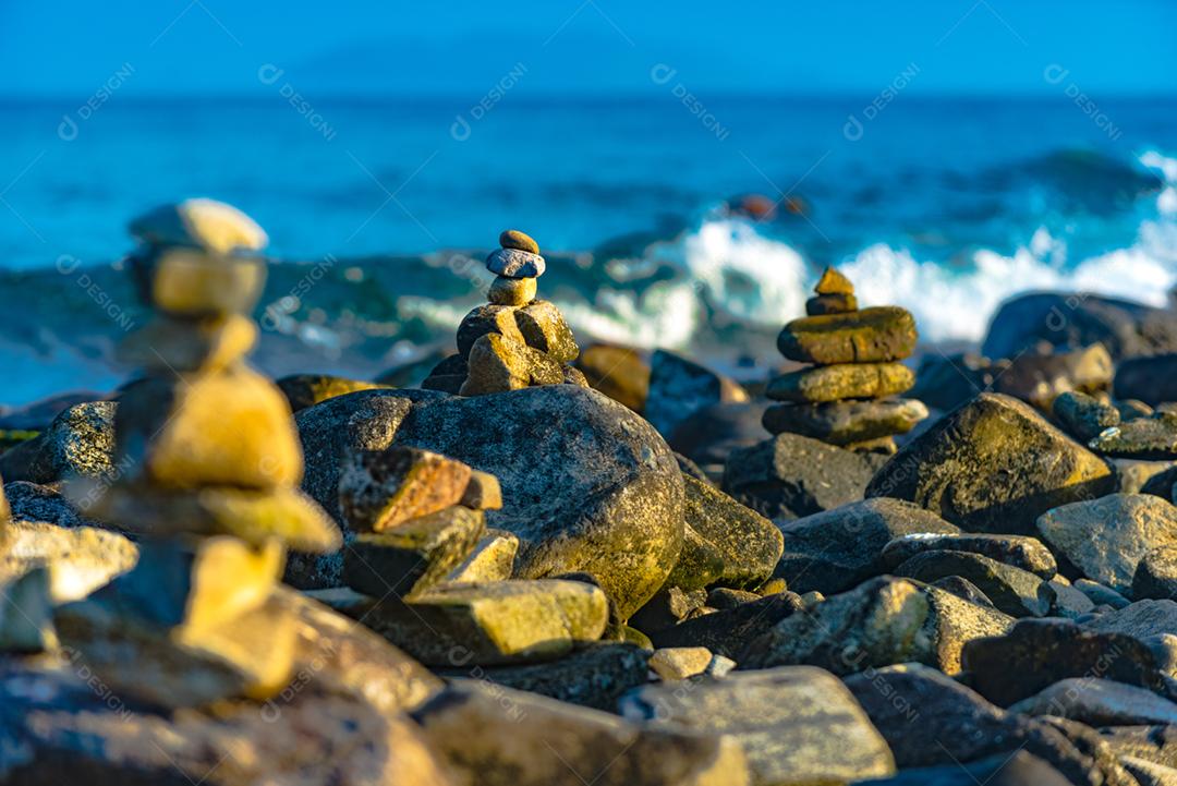 Paisagem por do sol praia pedreiras pedras rochas lago céu nublado