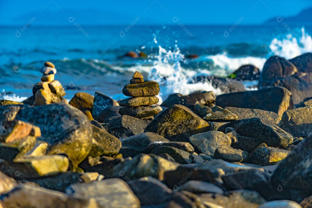 Paisagem por do sol praia pedreiras pedras rochas lago céu nublado