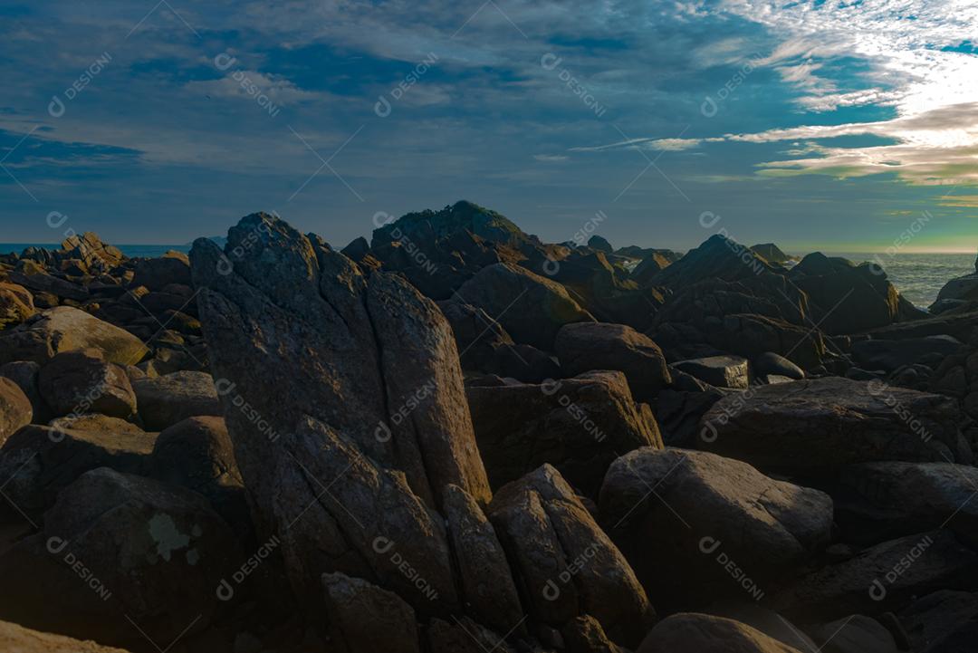 Paisagem por do sol praia pedreiras pedras rochas lago