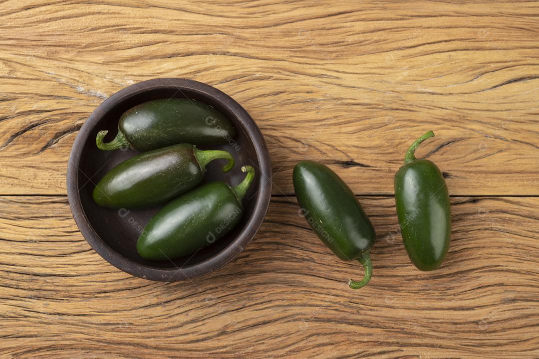 Pimentas verdes jalapeno em uma tigela sobre a mesa de madeira.